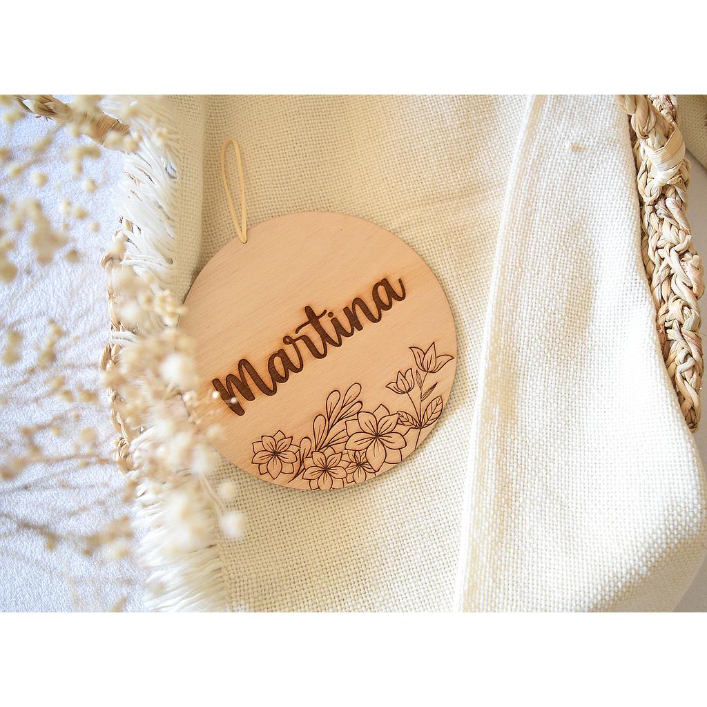 Cartel circular con grabado de flores debajo y nombre